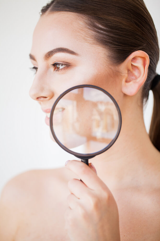 Woman Looking Through Magnifier Smiling Close Up (1)